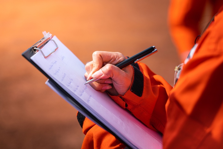 a workers is making notes on a clipboard