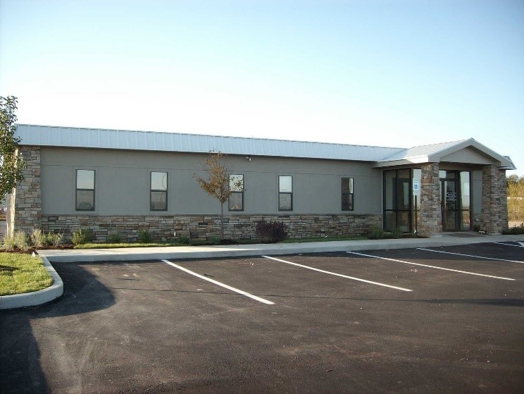 A completed modular building next to an empty parking lot.