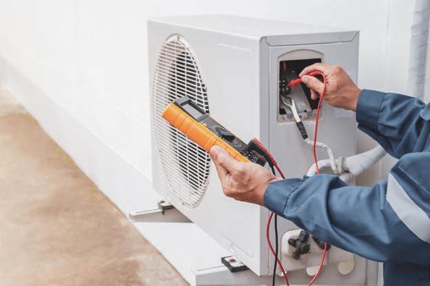 Technician checking on HVAC for maintenance.