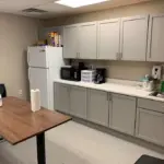 interior of modular educational building teacher lounge with counter table sink and refidgerator