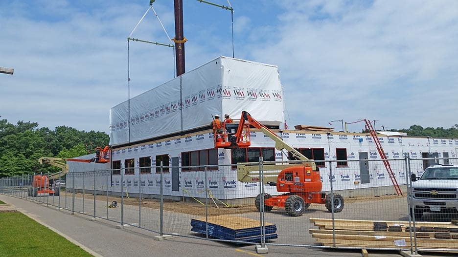 Constructed building modules being assembled on-site for a Nuclear Engineering Office building.